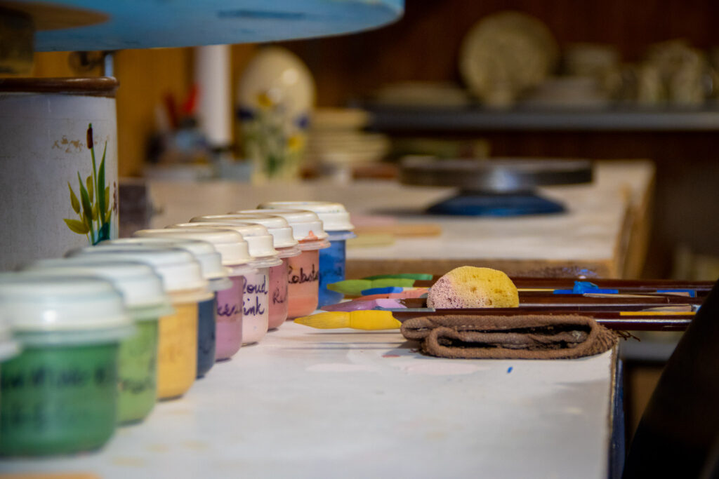 Paints and Paintbrushes lined up in a decorating studio.