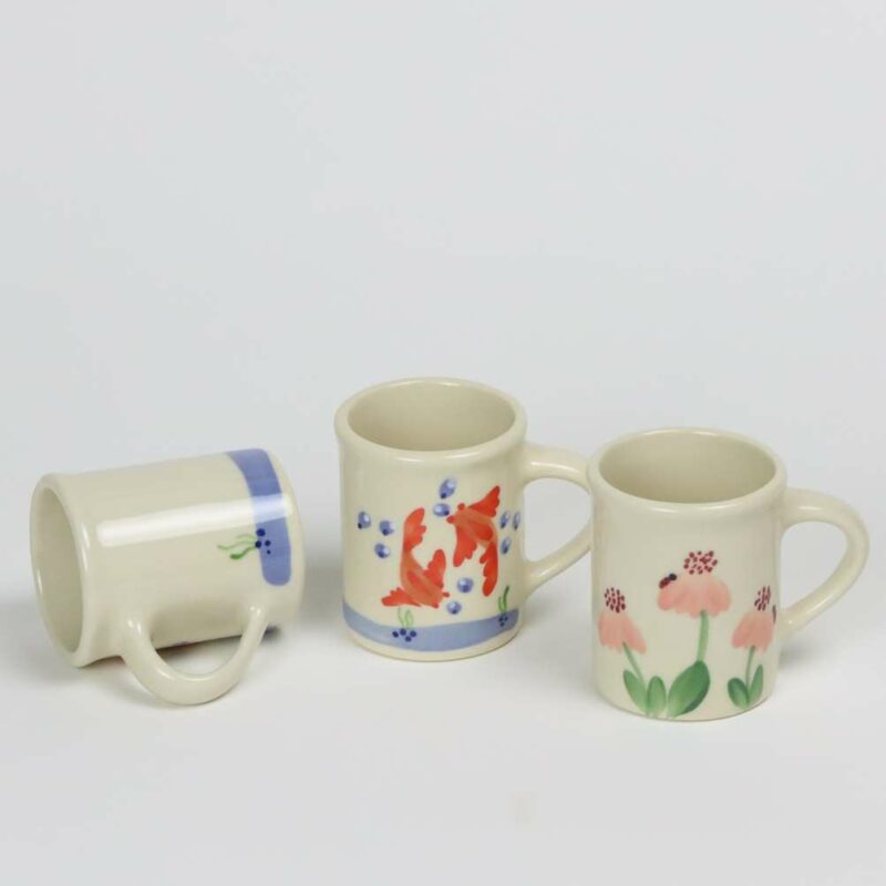 Selection of stoneware pottery Children's Cups in multiple glazes and hand-painted designs.