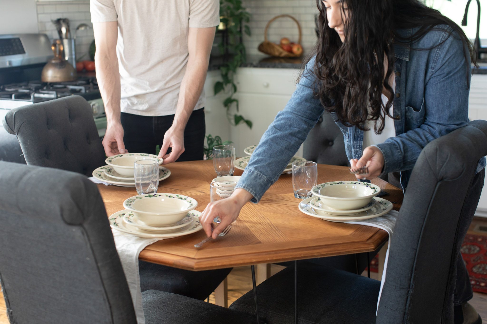 Friends setting a table with Blueberry Classic Dinnerware and coasters. Photo by Lauren Paige Photography.