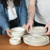 Hands holding Blueberry Classic Dinnerware and coasters. Photo by Lauren Paige Photography.